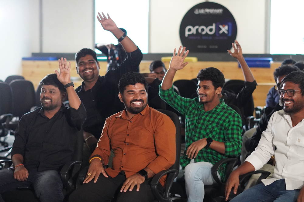 A row of students laughing with their hands in the air