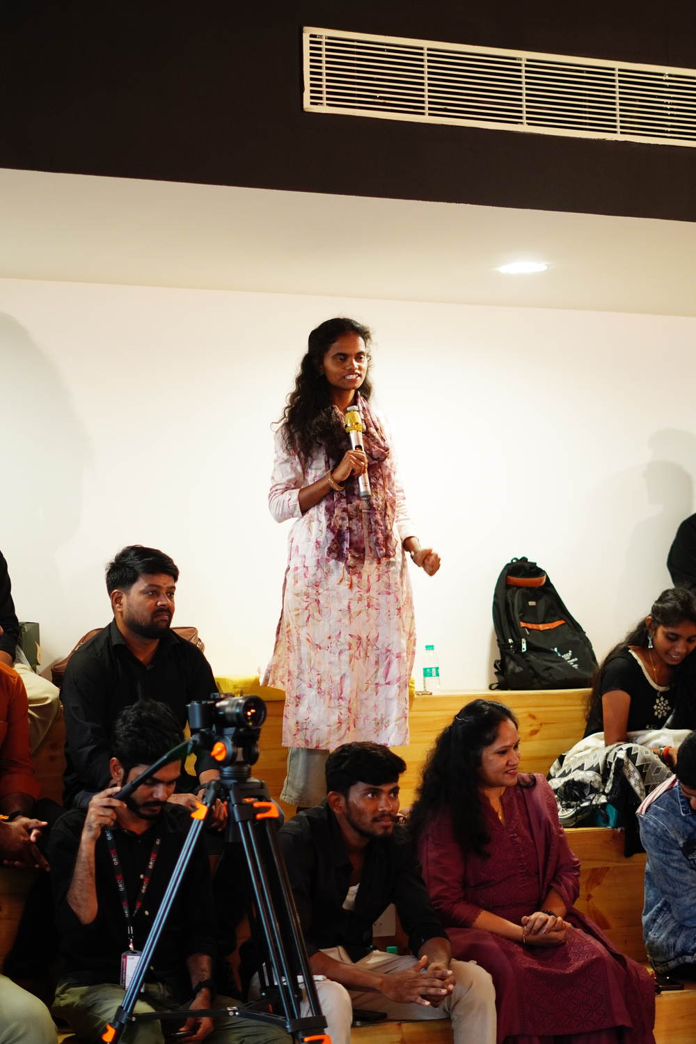 A student standing with the microphone to speak to the room